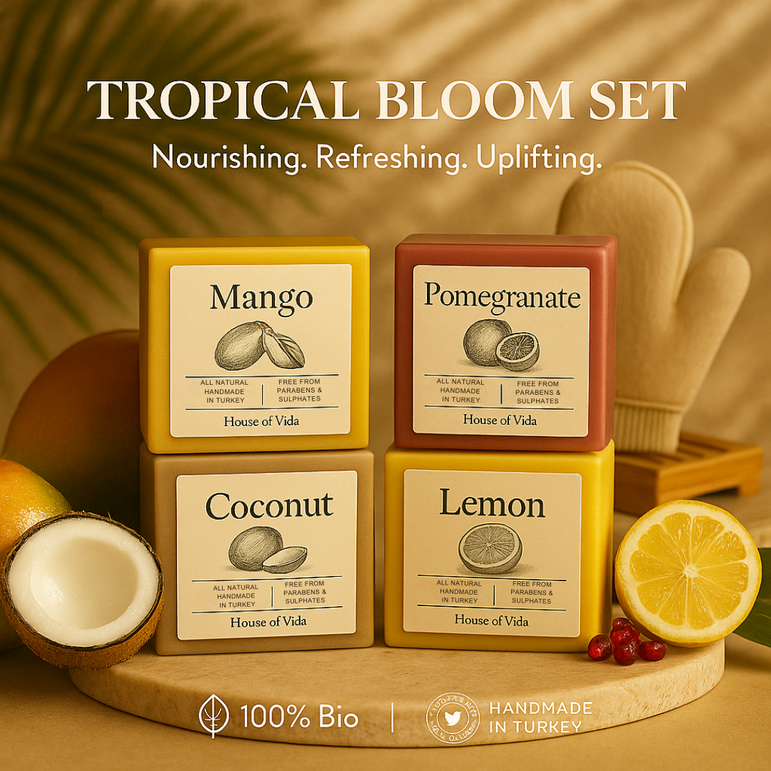 Four soap boxes labeled Mango, Pomegranate, Coconut, and Lemon on a wooden stand with tropical fruits around.