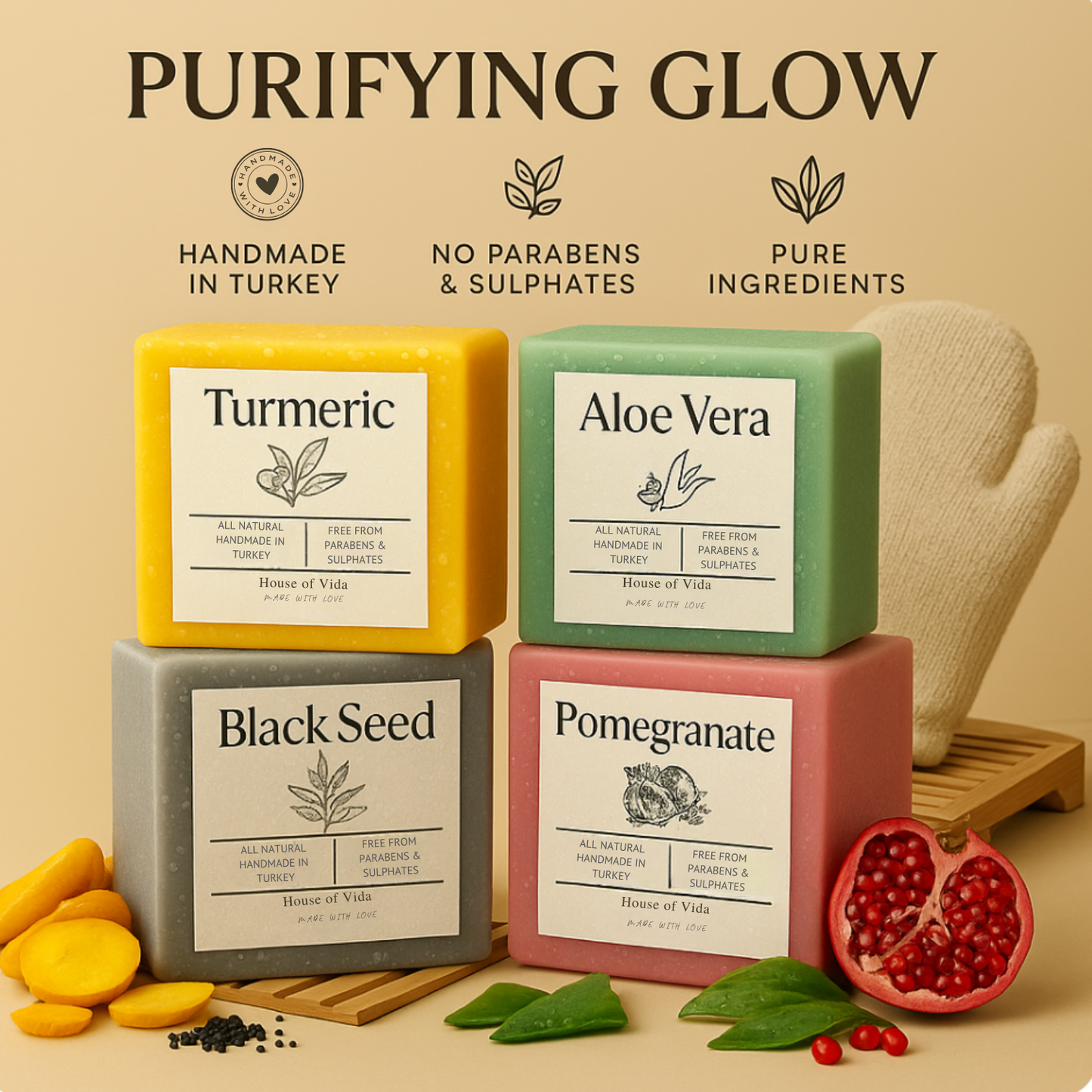 Four handmade soaps labeled Turmeric, Aloe Vera, Black Seed, and Pomegranate, displayed with corresponding natural ingredients like turmeric, aloe vera, black seeds, and pomegranate seeds, and a exfoliating shower glove.